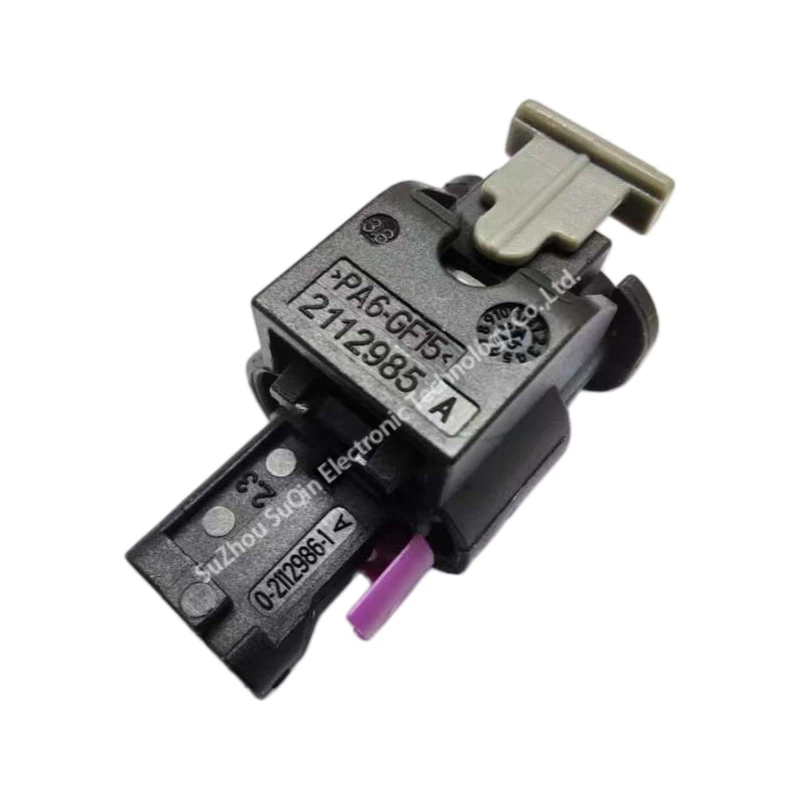 Close-up isometric view of the 1-1718643-1 housing sub-assembly showing molded material marking text PA6-GF15, component numbers 2112985 A and 0-2112986-1 A, a grey slider piece, and a purple terminal accent.