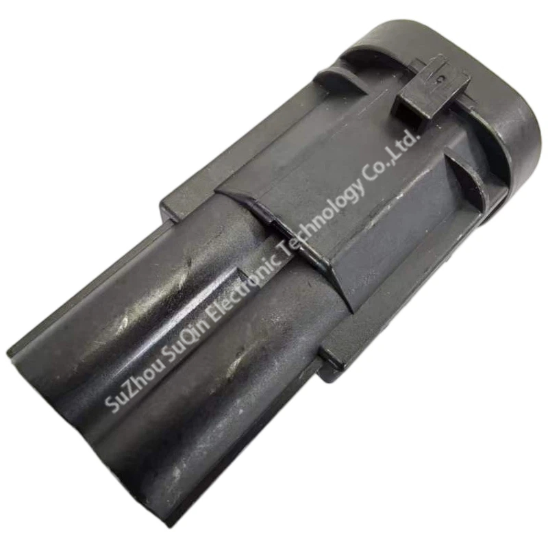 Isometric top view of the genuine black TE Connectivity 1544334-1 2-pin automotive male housing, showcasing its glass-filled PBT body and top lock lever.